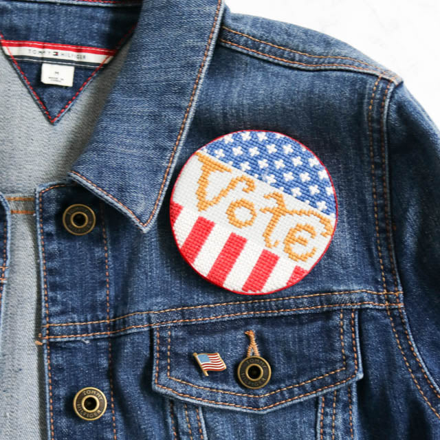 A handmade election button badge featuring a colorful design and text promoting a candidate or cause.