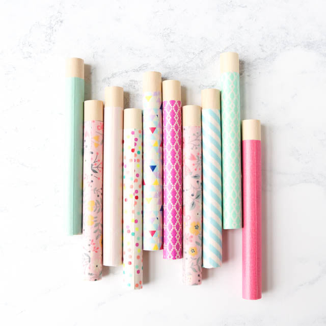 1. DIY wrapping paper tubes in various colors and patterns, arranged neatly on a table for creative gift wrapping.
