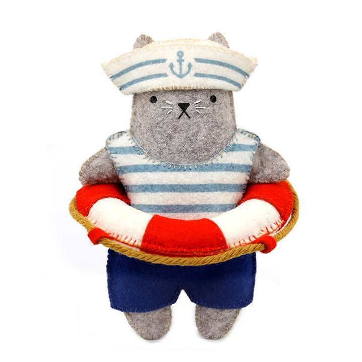 Stuffed toy bear dressed as a sailor with a life preserver on a white background